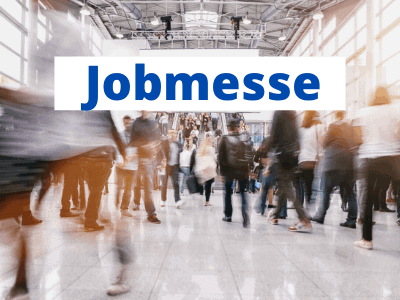 Eine verschwommene Menschenmenge in einer großen Halle mit heller Beleuchtung und hohen Decken. Das Wort Jobmesse erscheint in fetten blauen Buchstaben und hebt Möglichkeiten wie Jobcoaching München im Bild hervor.