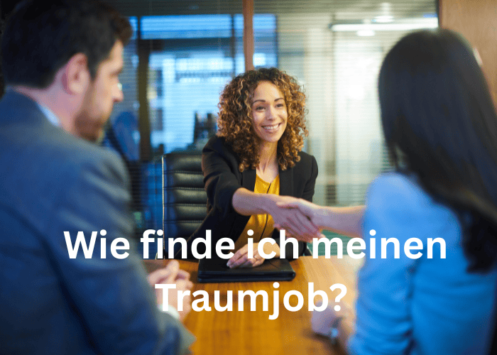 Eine lächelnde Frau mit lockigem Haar im Anzug schüttelt während eines Vorstellungsgesprächs einer anderen Person am Schreibtisch die Hand. Zwei Personen sind zu sehen. Der Text auf Deutsch lautet: Wie finde ich meinen Traumjob?.
