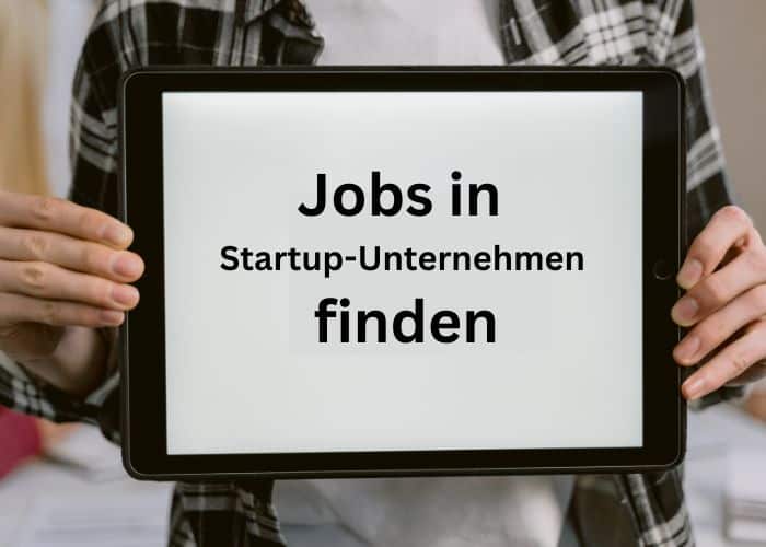 Eine Person, die ein Tablet in der Hand hält, auf dem der deutsche Text „Jobs in Startup-Unternehmen finden“ zu sehen ist, was so viel bedeutet wie „Jobs in Start-up-Unternehmen finden“. Die Person trägt ein kariertes Hemd.
