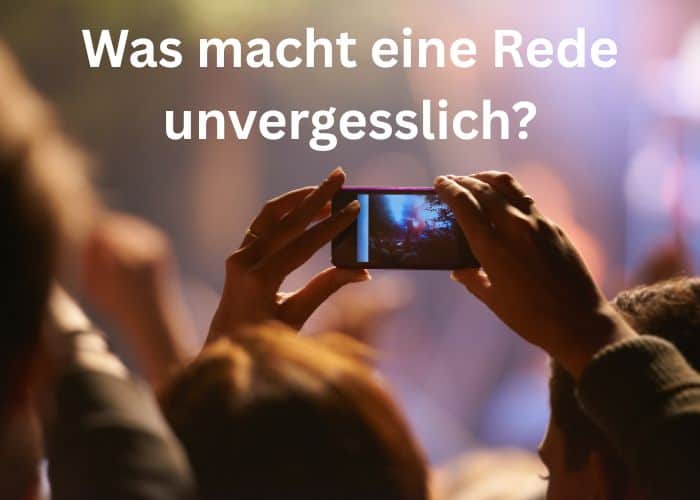 Eine Person hält ein Smartphone hoch, um ein Ereignis aufzunehmen; im Hintergrund sind verschwommene Gestalten zu sehen. Der Text auf Deutsch lautet: „Was macht eine Rede unvergesslich?“.